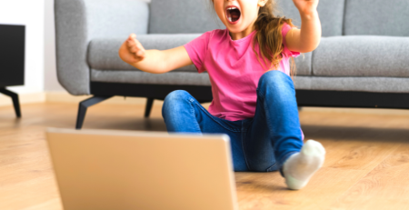 Excited little girl behind a laptop