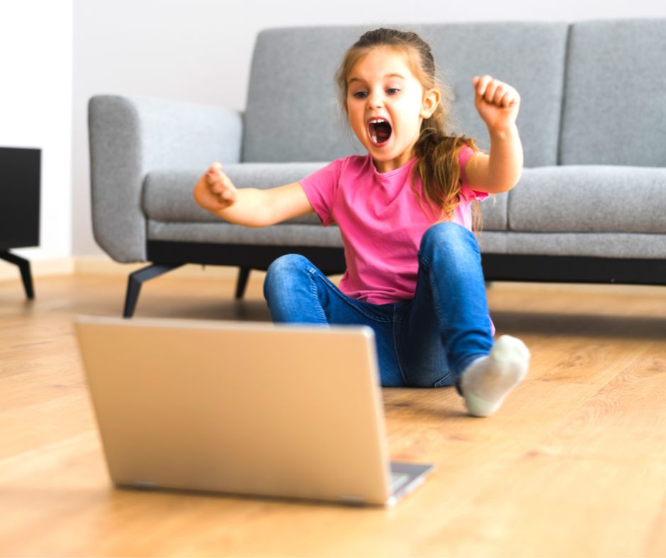 Excited little girl behind a laptop
