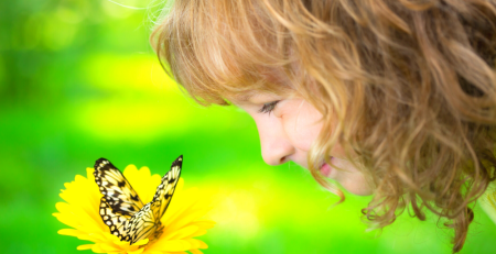 Girl watching a butterfly on a yellow flower