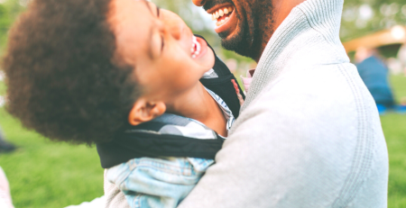 Father and young son laughing in a park