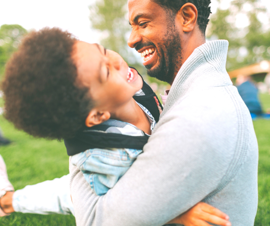 Father and young son laughing in a park