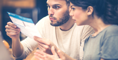 Shocked couple looking at a bill