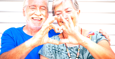 Senior couple forming a heart shape with their hands