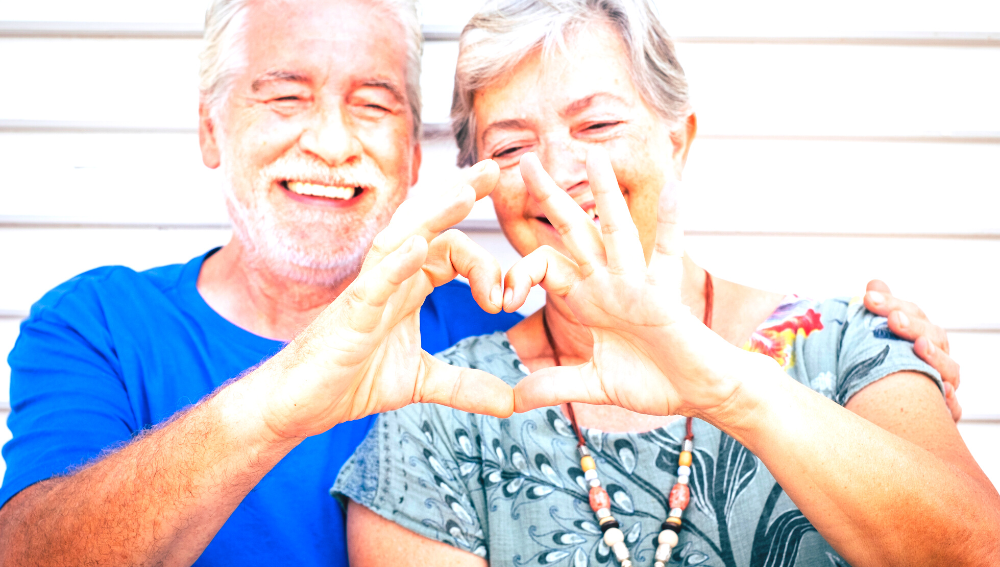 Senior couple forming a heart shape with their hands