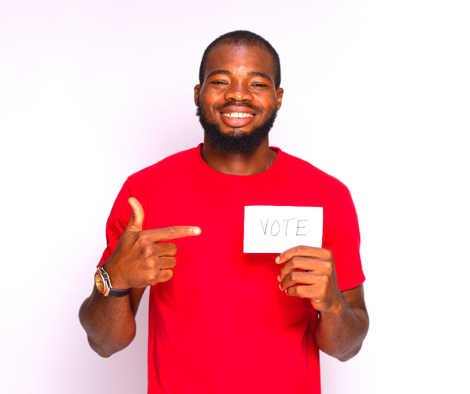 A man pointing to a card that says vote
