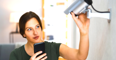 Woman adjusting security camera