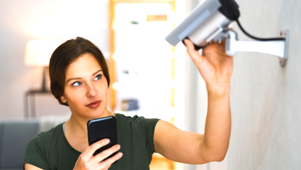 Woman adjusting security camera