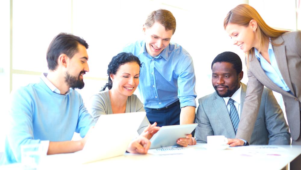 A group of smiling people discussing documents