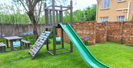 Picnic bench, jungle gym and waste bin from recycled plastic in a shared community scheme garden space