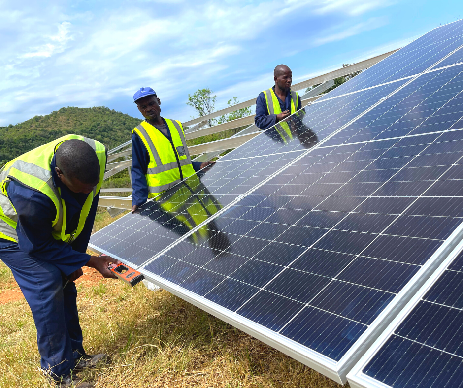 Workers installing ground-mounted solar panels