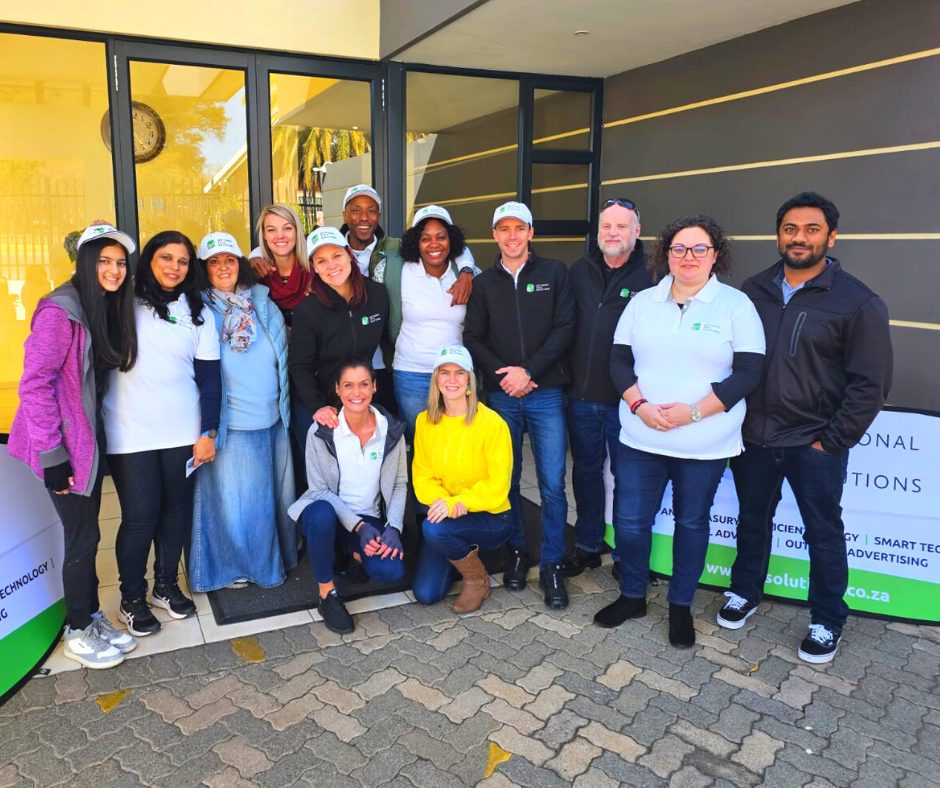 A group foto of the smiling group of STS volunteers in front of the entrance to the Alberton Old Age Home