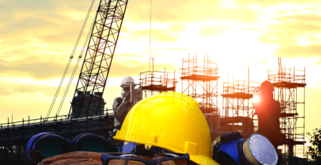 A hard hat and safety equipment in front of construction scaffolding