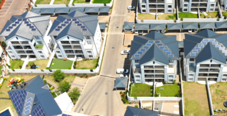 A wide angel photo of roof mounted solar panels at a community scheme from above