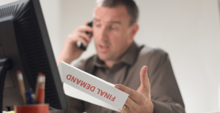 man on the pphone with a final demand letter in his hand