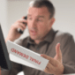 man on the pphone with a final demand letter in his hand
